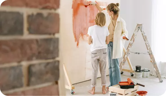 mama i dziecko malują ścianę w domu